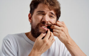 man holding face pain in teeth health problems dissatisfaction medicine